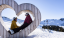 Ratschings-Jaufen – Pärchen sitzt in einem Holzherz im Skigebiet