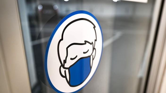 Regierung - Saarbrücken: Ein Aufkleber an einer Glastür weist auf das Tragen einer Maske hin. Foto: Felix Kästle/dpa/Symbolbild