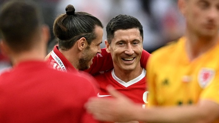 Fußball - München: Gareth Bale (2.v.l) von Wales und Robert Lewandowski von Polen unterhalten sich nach dem Spiel. Foto: Rafal Oleksiewicz/PA Wire/dpa/Archivbild