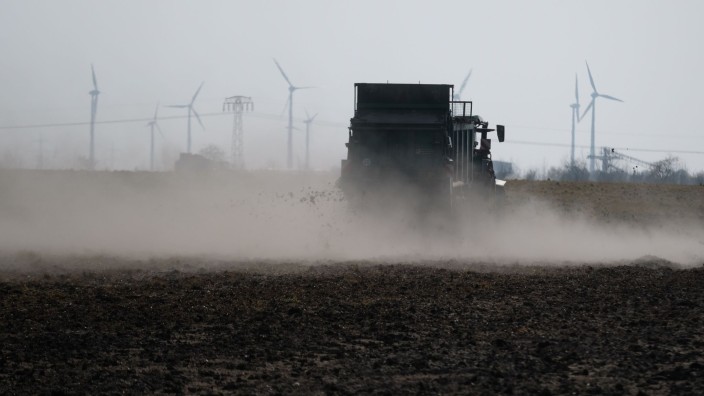 Wetter - Leipzig: Ein Traktor bringt Dünger aus, wobei als Folge von Dürre viel Staub aufgewirbelt wird. Foto: Sebastian Willnow/dpa-Zentralbild/dpa/Symbolbild