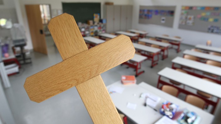 Justiz - Mannheim: Ein Kreuz wird im Klassenzimmer einer Grundschule gehalten. Foto: picture alliance /dpa/Illustration