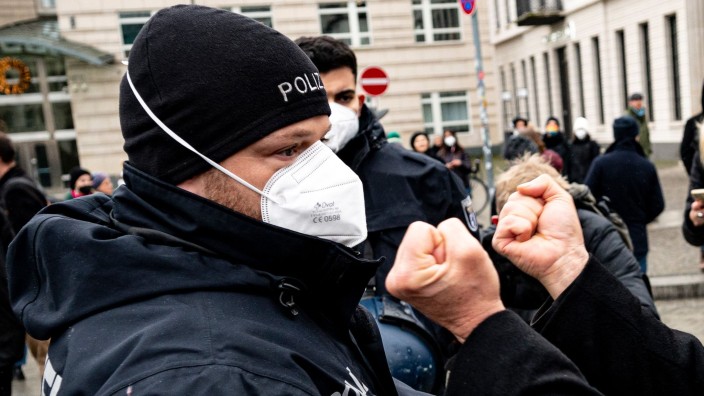 Kriminalität - München: Ein Demonstrant zeigt einem Polizisten die Fäuste. Foto: Fabian Sommer/dpa/Symbolbild