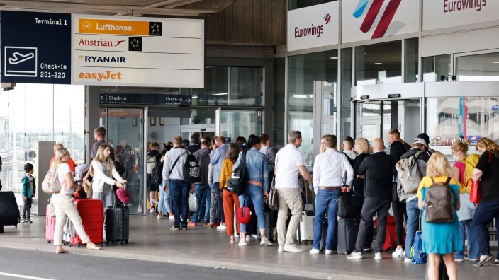 Luftverkehr - Düsseldorf: Reisende warten in einer Schlange am Terminal vor den Sicherheitskontrollen am Flughafen Köln/Bonn. Foto: Thomas Banneyer/dpa