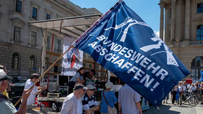 Demonstrationen - Berlin: Ein Teilnehmer hält bei einer Demonstration auf dem Bebelplatz eine Flagge mit der Aufschrift „Bundeswehr abschaffen!“. Foto: Christophe Gateau/dpa