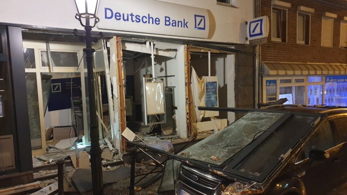 Banken - Düsseldorf: Ein beschädigtes Auto steht vor einer Bank, die durch eine Geldautomatensprengung verwüstet ist. Foto: Theo Titz/dpa/Symbolbild