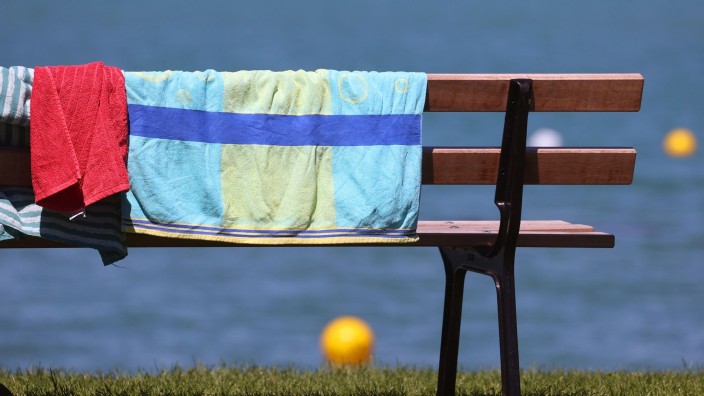 Schulen - München: Handtücher hängen am Ufer des Strandbades zum Trocknen über einer Bank. Foto: Karl-Josef Hildenbrand/dpa