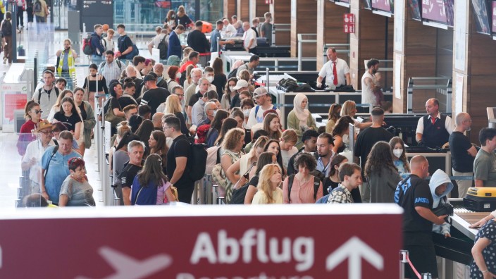 Reisen - Schönefeld: Zahlreiche Passagiere stehen in einer Schlange bei der Sicherheitskontrolle. Foto: Joerg Carstensen/dpa