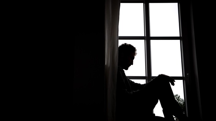 Gesundheit - Mainz: Ein Mann sitzt vor einem Fenster. Foto: Sina Schuldt/dpa/Illustration