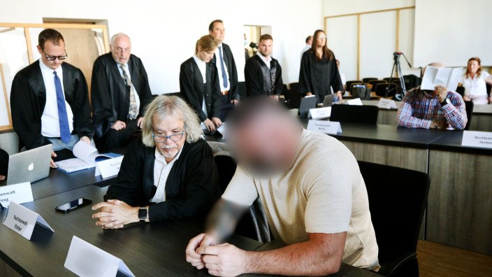Prozesse - Duisburg: Zwei von sechs Angeklagten (vorne r. und hinten r.) warten auf den Beginn des Prozesses. Foto: Roland Weihrauch/dpa