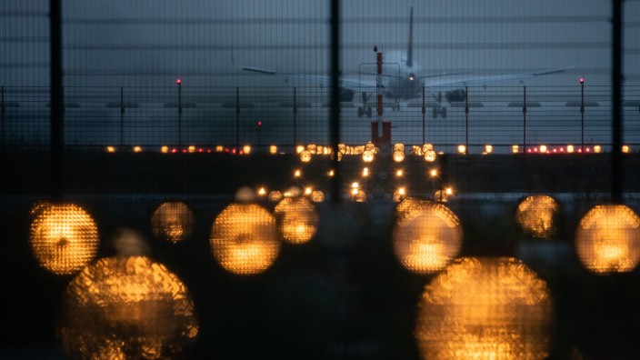 Demonstrationen - Schkeuditz: Ein Flugzeug landet hinter Signallichtern auf einem Flughafen. Foto: Sebastian Gollnow/dpa/Symbolbild