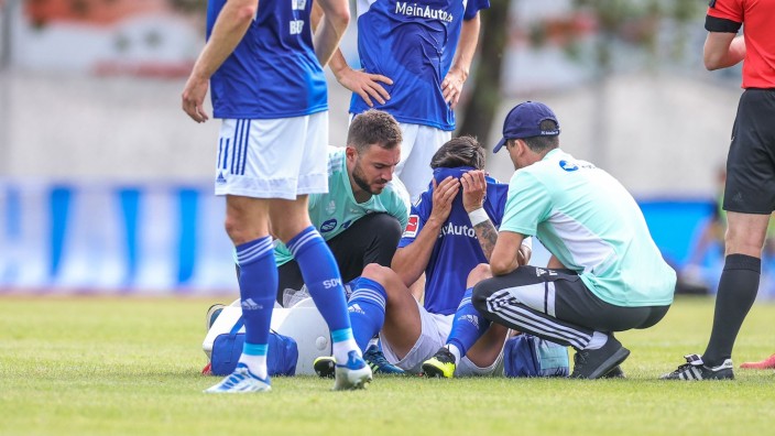 Fußball - Gelsenkirchen: Schalkes Danny Latza sitzt verletzt am Boden. Foto: Tim Rehbein/dpa