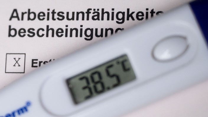 Krankheiten - Stuttgart: Ein Fieberthermometer liegt auf einer Arbeitsunfähigkeitsbescheinigung. Foto: Marijan Murat/dpa/Symbolbild