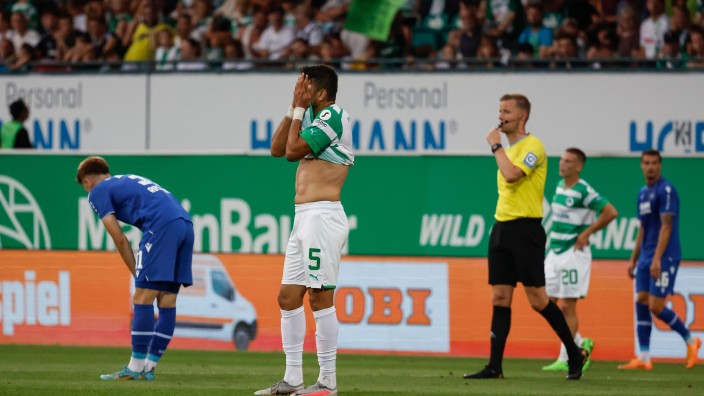 Fußball - Fürth: Der Karlsruher Tim Rossmann (l) und der Fürther Oussama Haddadi (M) sind nach dem 1:1 enttäuscht. Foto: Daniel Löb/dpa