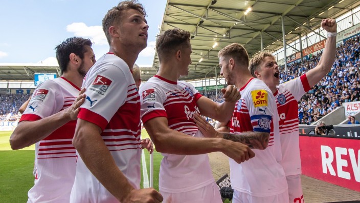 Fußball - Magdeburg: Die Mannschaft von Holstein Kiel jubelt ihren Fans nach dem Treffer zum 1:2 zu. Foto: Andreas Gora/dpa