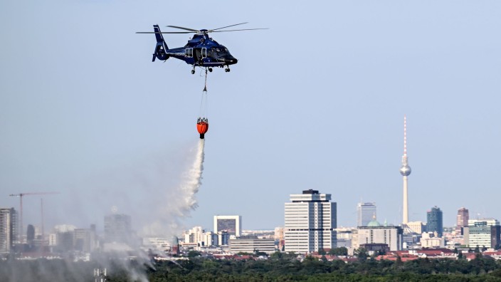 Brände - Berlin: Ein Hubschrauber der Bundespolizei wirft Wasser über der Brandstelle im Grunewald ab. Foto: Britta Pedersen/dpa/Archivbild