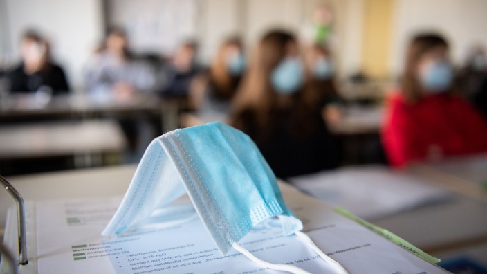 Bildung - Düsseldorf: Ein Mund-Nasen-Schutz liegt im Unterricht auf Unterlagen. Foto: Matthias Balk/dpa/Symbolbild