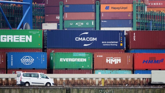 Schifffahrt - Hamburg: Ein Fahrzeug steht auf dem Gelände des Container Terminals Burchardkai (CTA) vor zahlreichen Containern. Foto: Julian Weber/dpa/Bildarchiv