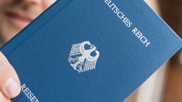 Regierung - Erfurt: Ein Mann hält ein Heftchen mit dem Aufdruck "Deutsches Reich Reisepass" in der Hand. Foto: Patrick Seeger/dpa/Symbolbild