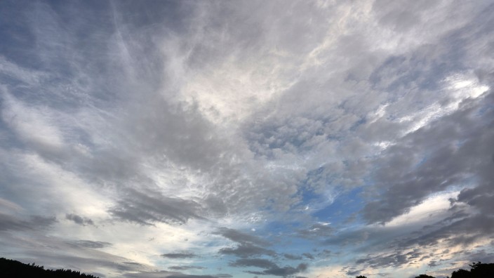 Wetter - Leipzig: Eine aufreißende Wolkendecke zieht über eine Wiese hinweg. Foto: Thomas Frey/dpa/Symbolbild