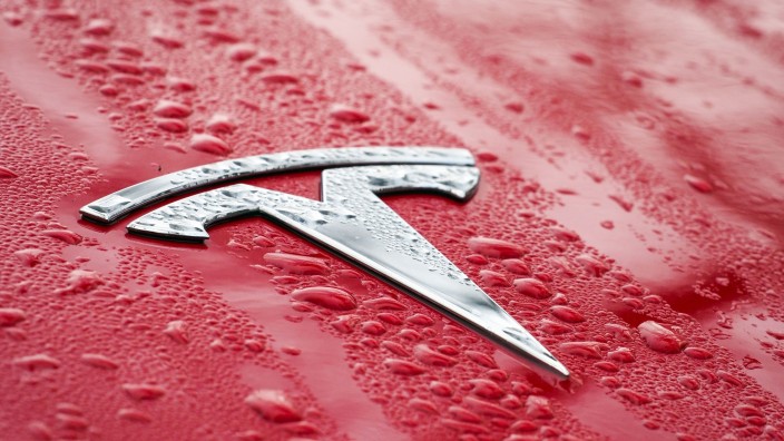 Auto - Grünheide (Mark): Das Logo auf der nassen Motorhaube eines roten Tesla. Foto: Soeren Stache/dpa-Zentralbild/dpa/Symbolbild