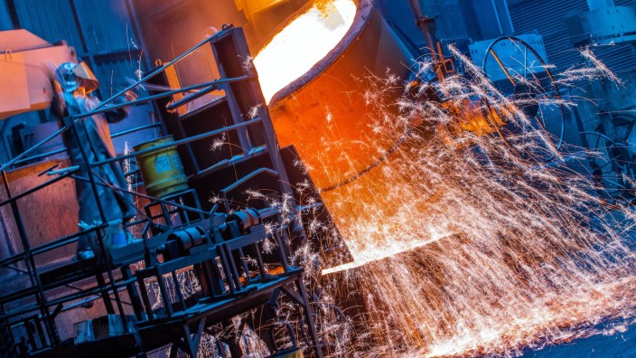 Elektro - Berlin: Die Temperatur von flüssigem Eisen wird von Arbeitern in einer Eisengießerei kontrolliert. Foto: Jens Büttner/dpa-Zentralbild/dpa/Archiv