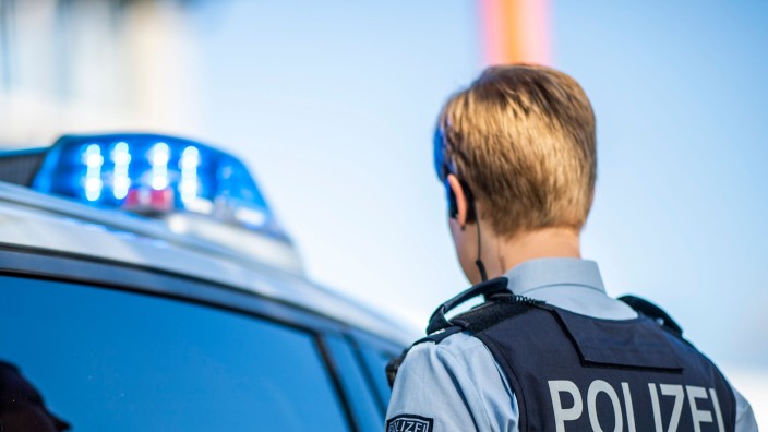Polizei - Berlin: Eine Polizistin steht vor einem Streifenwagen. Foto: David Inderlied/dpa/Illustration