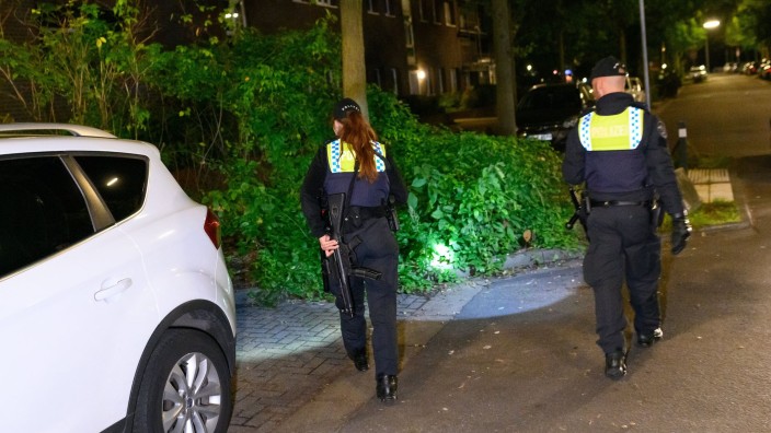Crime - Hamburg: A policewoman with a submachine gun and her colleague are looking for clues with flashlights. Photo: Jonas Walzberg/dpa