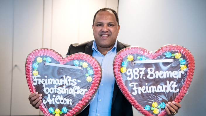 Customs - Bremen: Ailton holds two large gingerbread hearts. Photo: Sina Schuldt/dpa