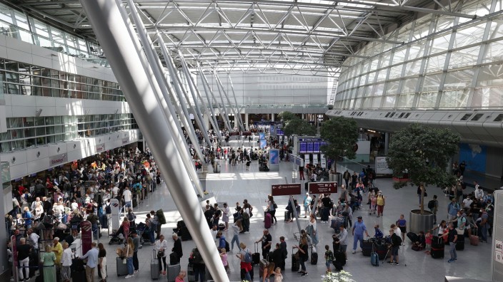 Luftverkehr - Düsseldorf: Reisende stehen im Flughafen in langen Warteschlangen an der Gepäckabgabe. Foto: David Young/dpa/Archivbild