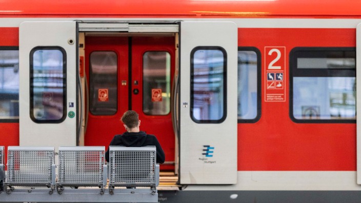 Bahn - München: Ein Mann sitzt an einem Bahnhof vor einem Regionalzug auf der Bank. Foto: Tom Weller/dpa/Symbolbild