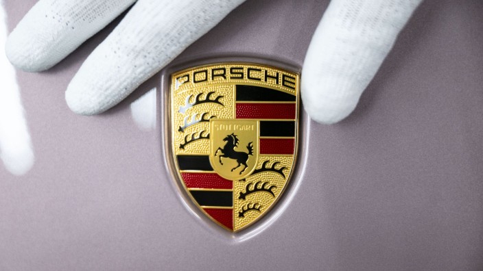 Auto - Frankfurt am Main: Ein Mitarbeiter der Porsche AG zeigt das Porsche-Logo. Foto: Marijan Murat/dpa/Symbolbild
