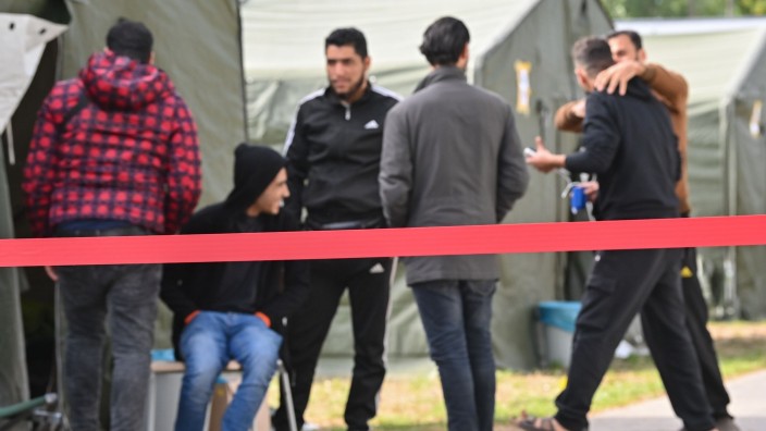 Flüchtlinge - Hannover: Migranten sind vor Zelten in der Zentralen Erstaufnahmeeinrichtung für Asylbewerber (ZABH) des Landes Brandenburg zu sehen. Foto: Patrick Pleul/dpa-Zentralbild/dpa/Bildarchiv