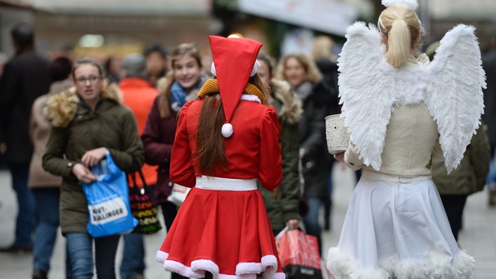 Handel - München: Zwei als Weihnachtsmann und Engel verkleidete Frauen verteilen in Münchens Innenstadt Lebkuchen. Foto: Andreas Gebert/dpa/Symbolbild