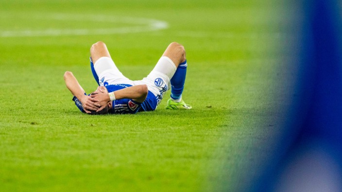 Fußball - Gelsenkirchen: Schalkes Tom Krauß liegt nach dem Schlusspfiff auf dem Boden. Foto: David Inderlied/dpa