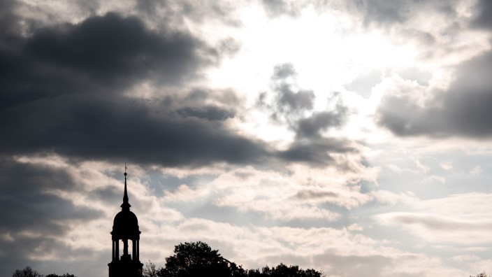 Energie - Hamburg: Sonne und Wolken sind hinter dem Turm der Hauptkirche St. Michaelis (Michel) zu sehen. Foto: Daniel Bockwoldt/dpa/Archivbild