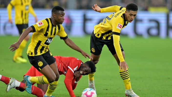 Fußball - Dortmund: Alphonso Davies (M) kämpft gegen Jude Bellingham (r) und Youssoufa Moukoko um den Ball. Foto: David Inderlied/dpa/Archivbild