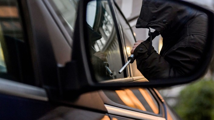 Auto - Berlin: Ein Mann versucht eine Autotür mit einer Metallstange aufzubrechen (gestellte Szene). Foto: Axel Heimken/dpa/Illustration