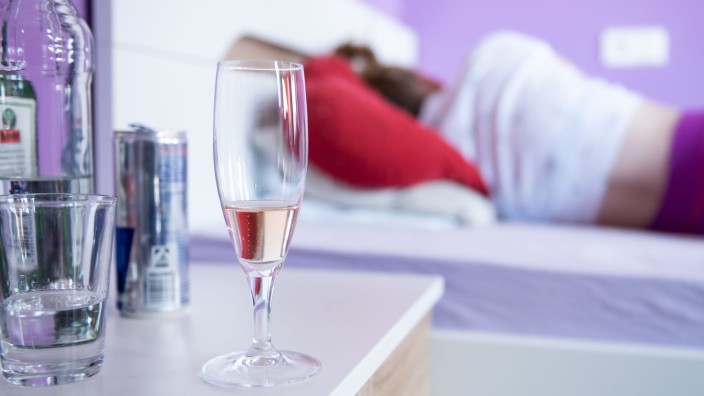 Gesundheit - Schwerin: Eine Frau liegt in ihrem Bett, neben dem Flaschen und Gläser mit Alkohol stehen. Foto: Silas Stein/dpa/Symbolbild