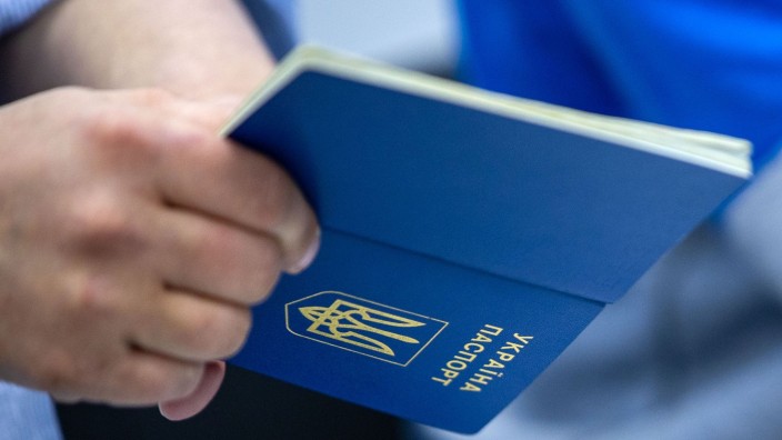 Flüchtlinge - Nürnberg: Ein Mann hält einen ukrainischen Reisepass in der Hand. Foto: Jens Büttner/dpa/Symbolbild