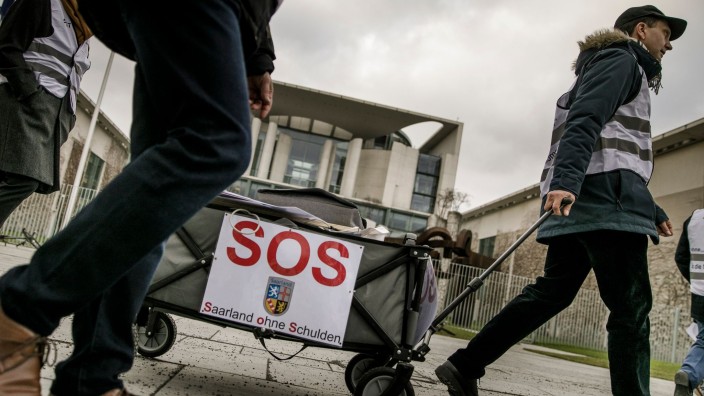 Finanzen - Saarbrücken: Bei einer Protestaktion wird ein Karren mit der Aufschrift "SOS - Saarland ohne Schulden" gezogen. Foto: Carsten Koall/dpa/Archivbild