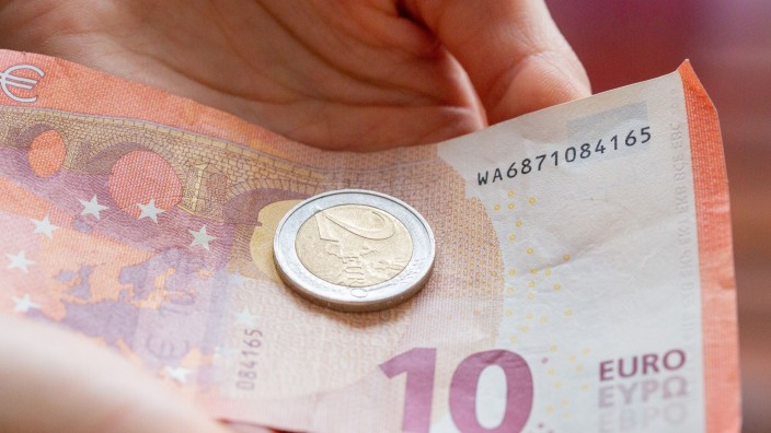 Einkommen - Wiesbaden: Eine Person hält 12 Euro in der Hand. Foto: Fernando Gutierrez-Juarez/dpa-Zentralbild/dpa/Symbolbild