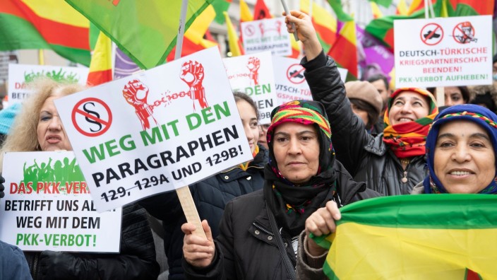 International - Berlin: Teilnehmerinnen stehen am Hermannplatz und halten Fahnen und Schilder . Foto: Paul Zinken/dpa