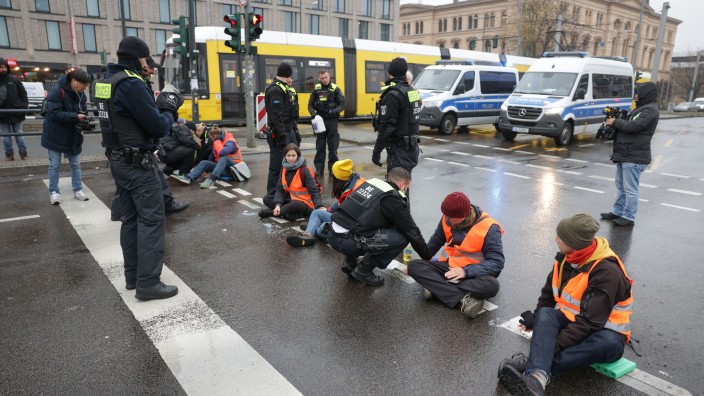 Demonstrationen - Berlin: Polizisten lösen die Hand eines Klimaaktivisten vom Asphalt auf der Invalidenstraße. Foto: Jörg Carstensen/dpa