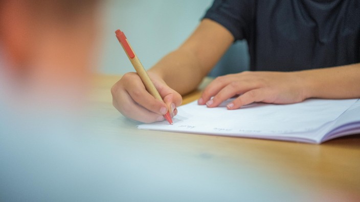 Krankheiten - Düsseldorf: Ein Grundschüler sitzt an einem Tisch und schreibt mit einem Kugelschreiber in sein Heft. Foto: Mohssen Assanimoghaddam/dpa/Symbolbild