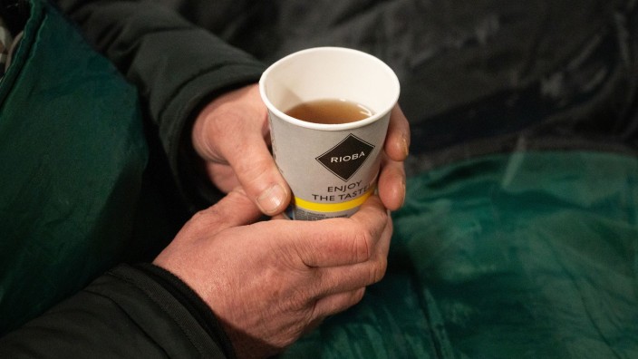 Fußball - Berlin: Ein Obdachloser hält einen Becher Tee in der Hand. Foto: Christophe Gateau/dpa/Symbolbild