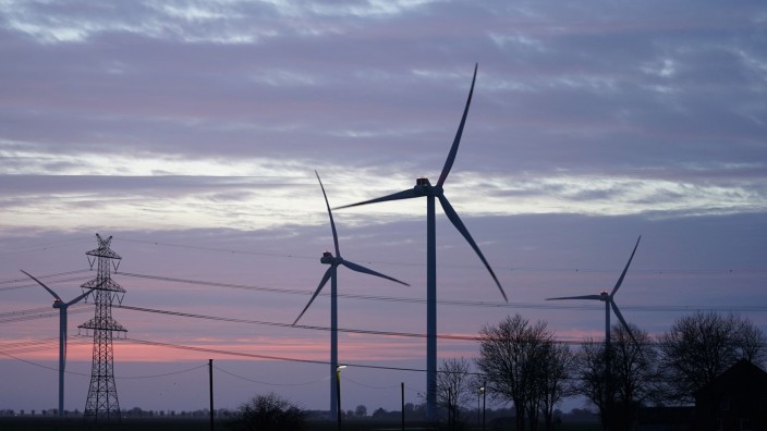 Energie - Düsseldorf: Windräder und Stromleitungen sind im Abendlicht zu sehen. Foto: Marcus Brandt/dpa/Symbolbild
