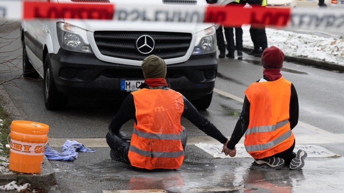 Demonstrationen - München: Zwei Klimaaktivisten nehmen an einer Protestaktion der Gruppe Letzte Generation teil. Foto: Peter Kneffel/dpa/Archivbild
