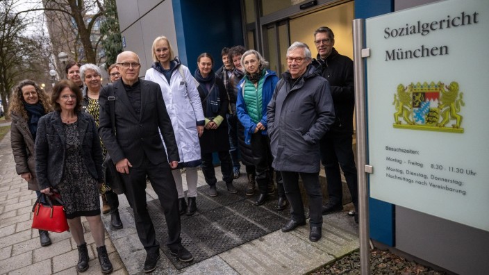 Prozesse - München: Der Augenarzt Gernot Petzold (vorne, 2.v.l) und einige Mitstreiter stehen vor Prozessbeginn vor dem Sozialgericht. Foto: Peter Kneffel/dpa