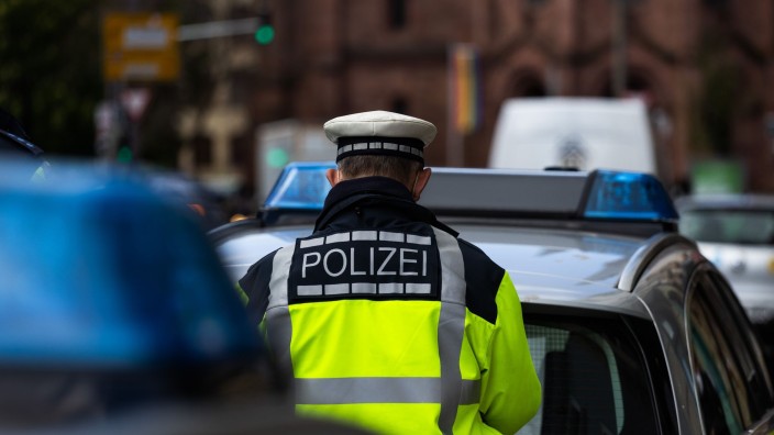 Kriminalität - Marktoberdorf: Ein Polizeibeamter steht zwischen zwei Einsatzfahrzeugen der Polizei. Foto: Philipp von Ditfurth/dpa/Symbolbild