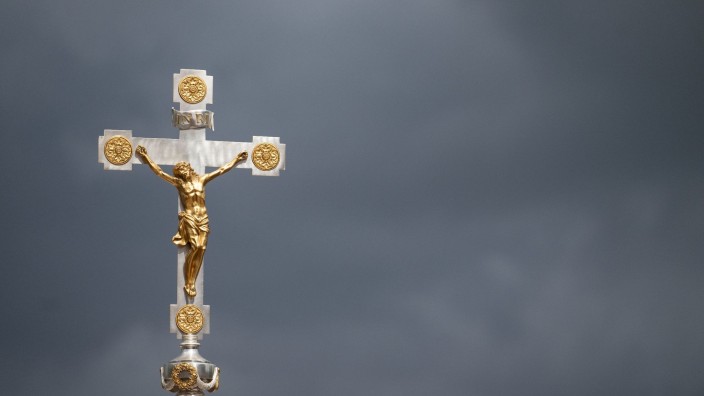 Kirche - München: Ein katholisches Kruzifix ist vor dunklen Wolken zu sehen. Foto: Marijan Murat/dpa/Symbolbild